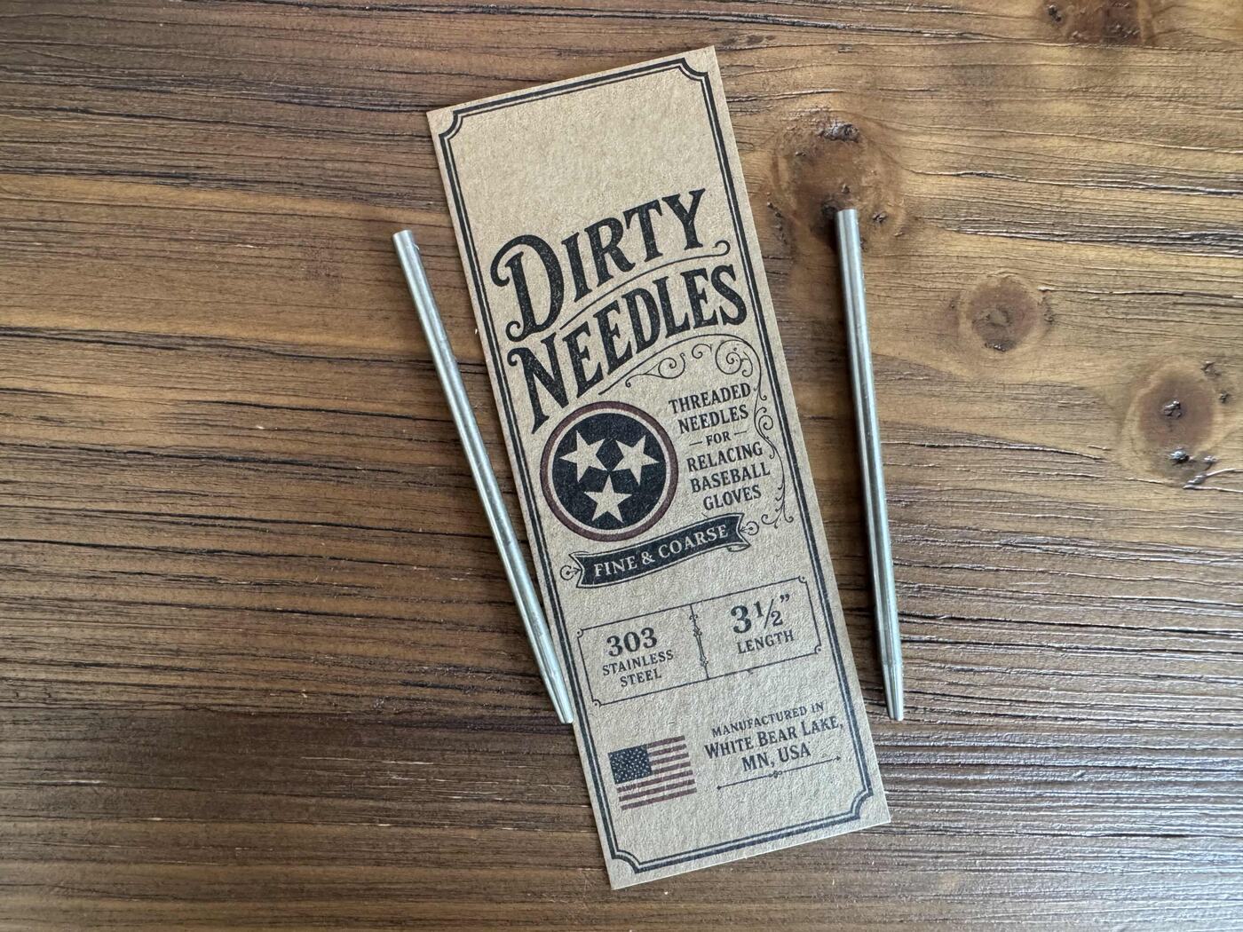 Two 3½ inch relacing needles, fine and coarse, beside their kraft Dirty Needles card